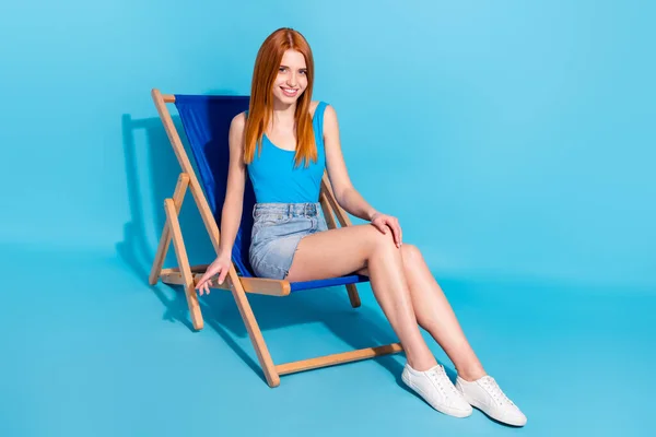밝은 파란색 배경으로 격리 된 의자 풀장에 앉아 무료 여가를 즐기는 쾌활 한 소녀의 모습 — 스톡 사진