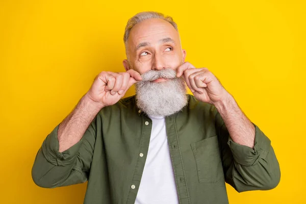 Foto ritratto di uomo anziano toccare i baffi cercando spazio vuoto sognante isolato vibrante colore giallo sfondo — Foto Stock