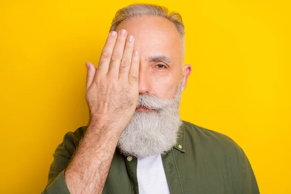 Φωτογραφία πορτρέτο του ηλικιωμένου άνδρα σοβαρή κλείσει μισό πρόσωπο με το χέρι απομονώνονται ζωντανό κίτρινο χρώμα φόντο — Φωτογραφία Αρχείου