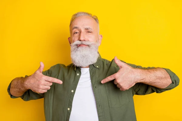 Фотопортрет старшого чоловіка в зеленій сорочці, що вказує пальці на себе, демонструючи впевнений ізольований яскраво-жовтий кольоровий фон — стокове фото