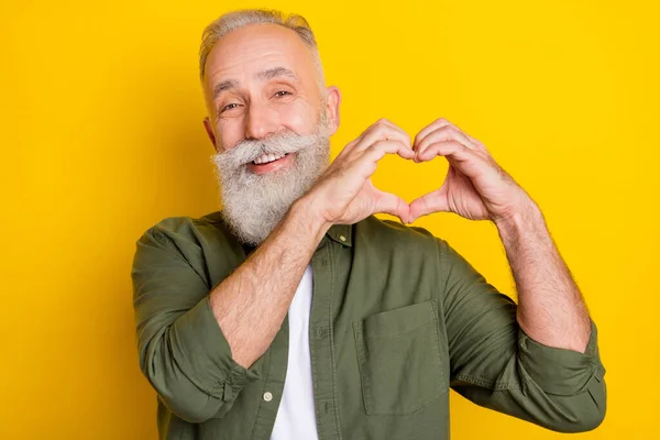 Foto porträtt av farfar ler glad visar hjärtformade tecken isolerad levande gul färg bakgrund — Stockfoto