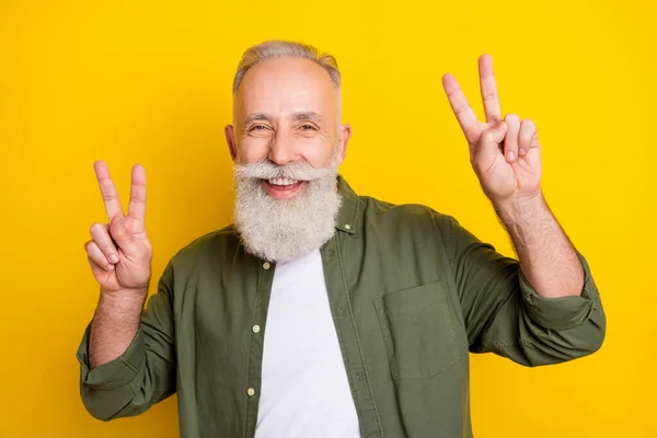 Foto porträtt av farfar leende visar v-tecken gest isolerad levande gul färg bakgrund — Stockfoto