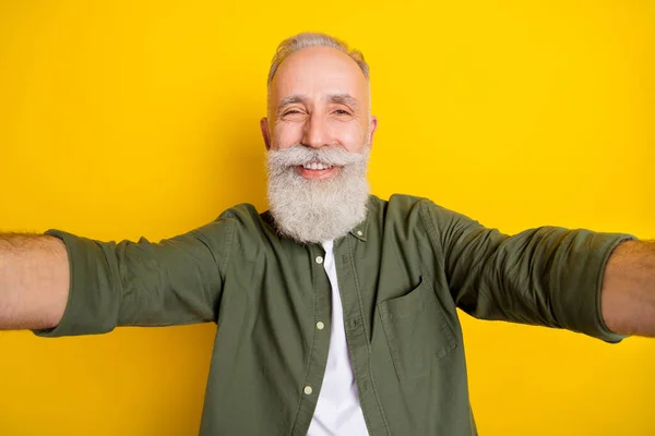 Foto porträtt av farfar tar selfie på kameran ler isolerad ljus gul färg bakgrund — Stockfoto