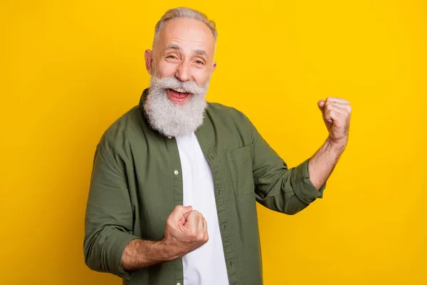 Foto retrato del abuelo haciendo gestos como ganador sonriendo alegre aislado vívido color amarillo fondo — Foto de Stock