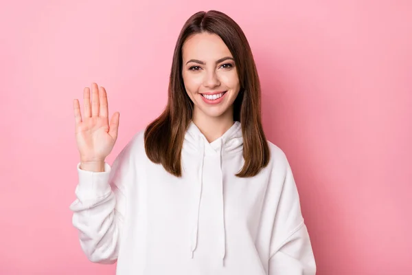 Φωτογραφία του νεαρού ελκυστικό κορίτσι ευτυχής θετικό χαμόγελο χαιρετισμό χαιρετισμό χέρι απομονώνονται πάνω από ροζ φόντο χρώμα — Φωτογραφία Αρχείου