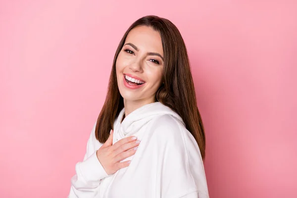 Profilseite Foto von jungen attraktiven Mädchen glücklich positives Lächeln Hand berühren Brust lachen isoliert über rosa Farbhintergrund — Stockfoto