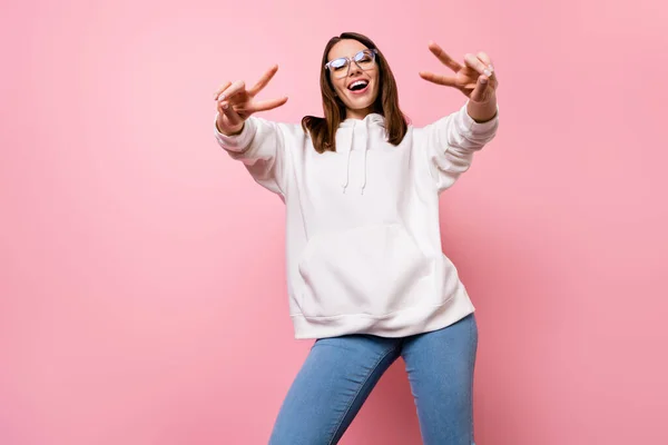 Foto de encantador jovem feliz mulher agradável mostrar v-canta sorrir usar óculos isolados no fundo cor-de-rosa — Fotografia de Stock