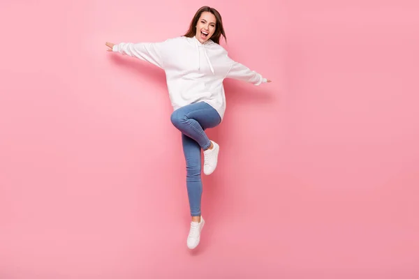 Foto di dolce adorabile giovane signora indossare felpa bianca con cappuccio sorridente salto alto mani lati isolato colore rosa sfondo — Foto Stock