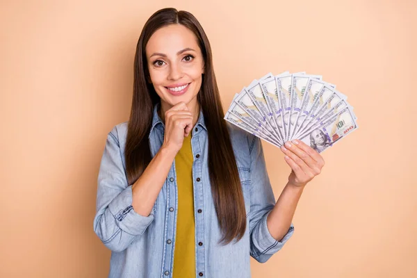 Foto von jungen attraktiven weiblichen halten Fan von USD-Dollar Geld glücklichen Gewinner Gewinn isoliert auf beige Hintergrund — Stockfoto
