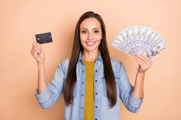 Foto von ziemlich attraktiven Dame halten zeigen Kreditkarte viel Geld Gehalt Einkommen isoliert auf beige Hintergrund — Stockfoto