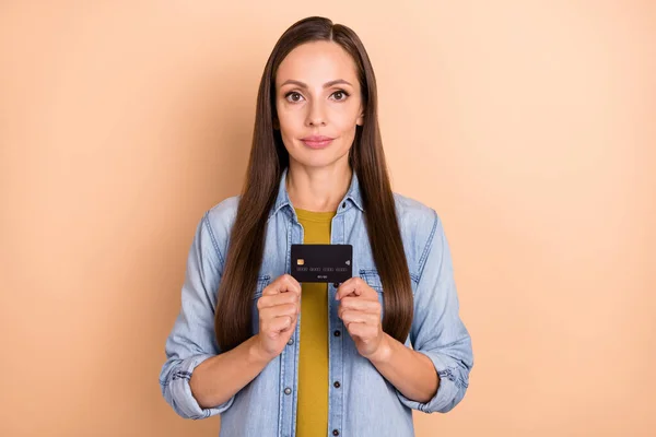 Foto av positiva snygga kvinnliga håll kreditkort reklam produkt bank isolerad på beige färg bakgrund — Stockfoto