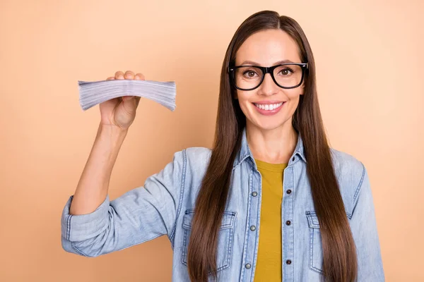 Foto von fröhlichen Geschäftsfrau in Brille halten Stapel von Geld Gehalt Einkommen isoliert auf beige Hintergrund — Stockfoto