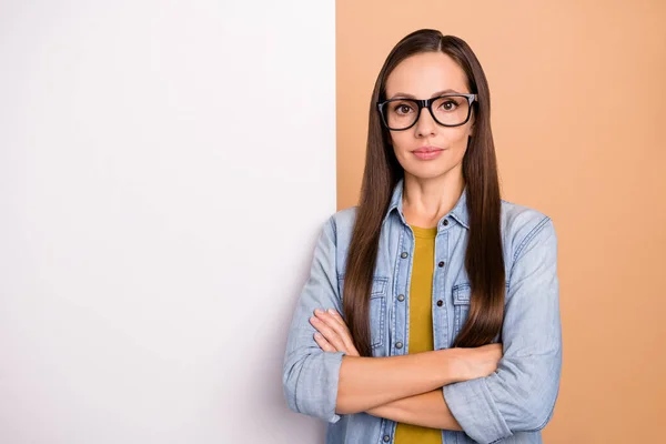 Foto di cool grave donna d'affari in posa con la pubblicità cartello bianco isolato su sfondo di colore beige — Foto Stock