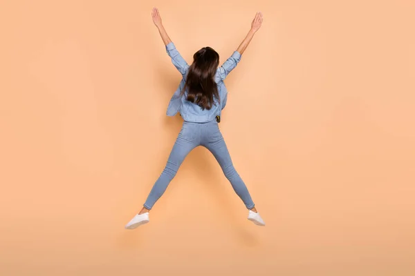 Foto de tamaño completo de chica despreocupada funky saltando levantar las manos en la victoria mejora personal aislado sobre fondo de color beige —  Fotos de Stock
