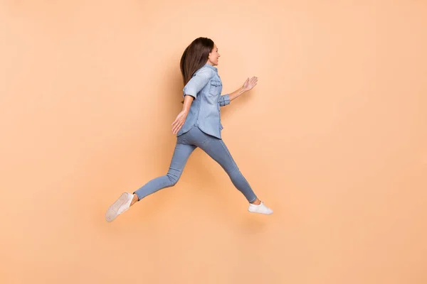 Foto lateral de perfil de tamaño completo de una mujer joven que viaja corriendo espacio de copia de aspecto rápido aislado en fondo de color beige —  Fotos de Stock