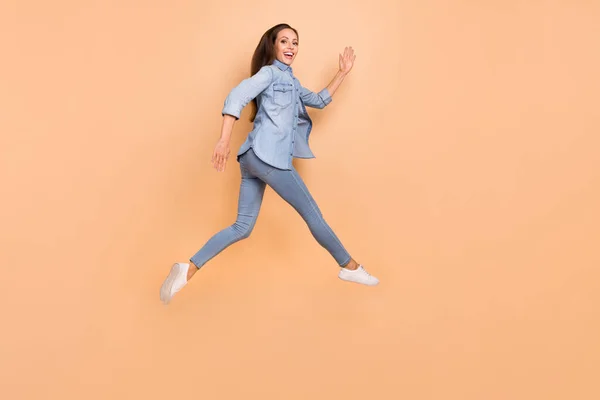 Profil pleine grandeur photo de côté de fille maigre courir dans l'air relaxant le week-end d'été isolé sur fond de couleur beige — Photo