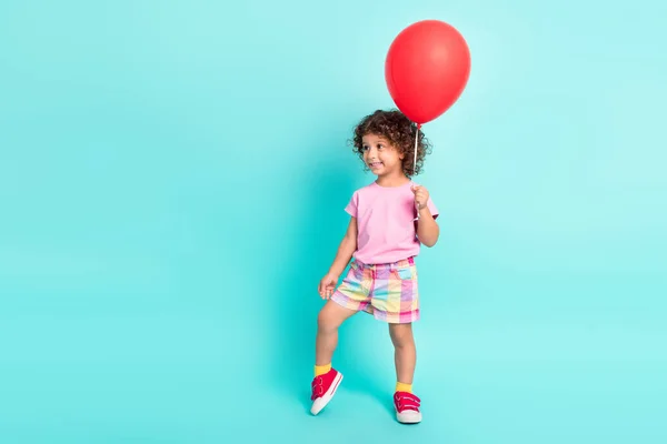 Volledige lengte foto van jonge kleine Spaanse meisje blij positieve glimlach houden luchtballonnen geïsoleerd over turquoise kleur achtergrond — Stockfoto