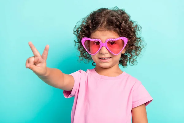 Портрет привлекательной веселой девушки в больших очках с V-знаком, изолированным на ярко-бирюзовом фоне — стоковое фото