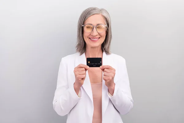 Foto von optimistischen weißen Frisur ältere Managerin halten Karte tragen Brille Jacke isoliert auf grauem Hintergrund — Stockfoto