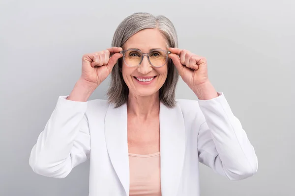 Foto av optimistisk vit frisyr åldrad chef dam bära glasögon jacka isolerad på grå färg bakgrund — Stockfoto