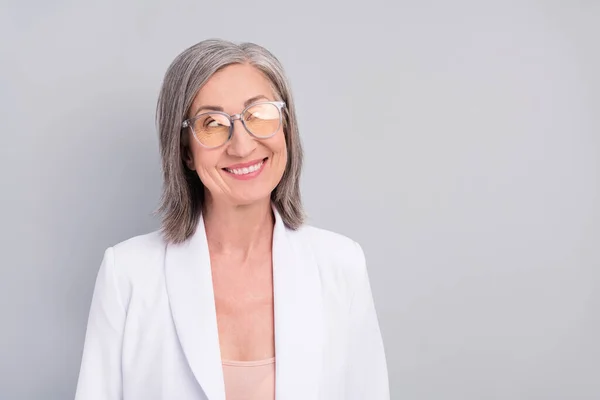 Photo de la coiffure blanche impressionnée dame âgée regarder vide espace porter blazer lunettes isolé sur fond de couleur grise — Photo