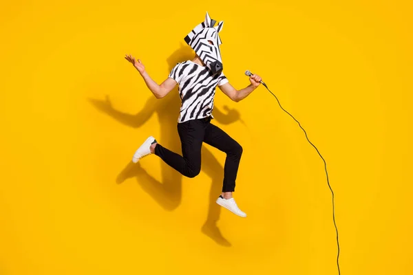 Largura completa foto de loco raro chico rockero en cebra máscara salto arriba cantar micrófono aislado sobre brillo amarillo color fondo — Foto de Stock