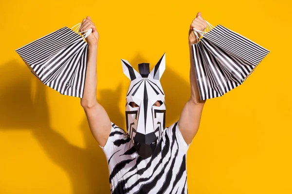 Foto van gelukkige vrolijke man dragen zebra print t-shirt masker stijgende shopping koopjes geïsoleerde gele kleur achtergrond — Stockfoto