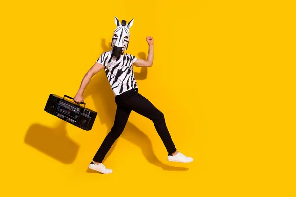 In voller Länge Profil Seite Foto von bizarren Kerl in Zebra-Maske halten Boom Box Walk Disco gewinnen Faust-up isoliert über gelben Farbhintergrund — Stockfoto