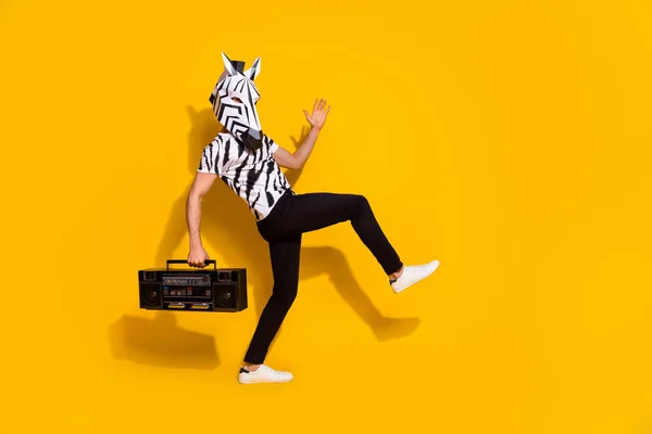 Foto de tipo escalofriante vestido disfraz de animal salvaje sosteniendo boom box caminando espacio vacío aislado color amarillo fondo — Foto de Stock