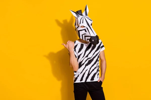 Foto von exzentrischen funky Mann tragen Zebra-Print T-Shirt-Maske zeigt Daumenfinger leeren Raum isoliert gelb Hintergrund — Stockfoto