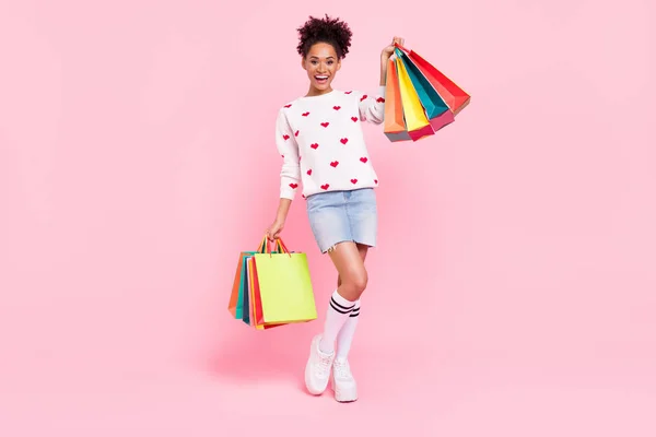 Foto de tamaño completo de la fresca dama milenaria morena sostienen muchos paquetes usan suéter falda calcetines zapatos aislados sobre fondo rosa — Foto de Stock