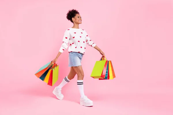 Foto de perfil de longitud completa de agradable morena joven dama hacer compras usar suéter falda calcetines zapatos aislados sobre fondo rosa — Foto de Stock