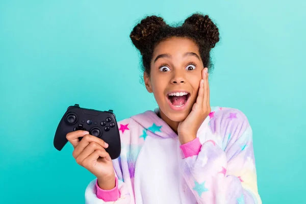 Foto de joven emocionado afro chica mano toque mejilla fiesta pijamada juego camisón aislado sobre fondo de color turquesa —  Fotos de Stock