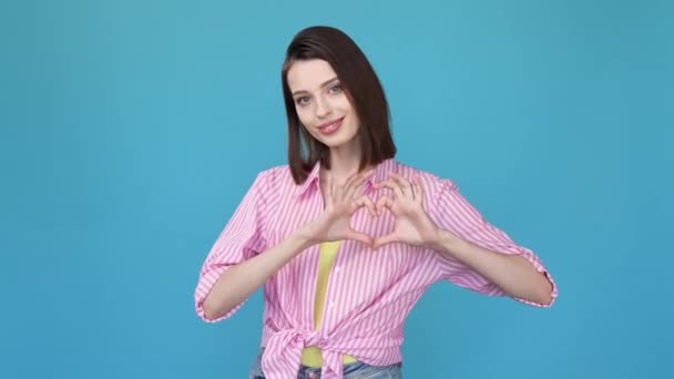 Szép hölgy, hogy szív alakú kéz ellátás elszigetelt kék szín háttér — Stock videók