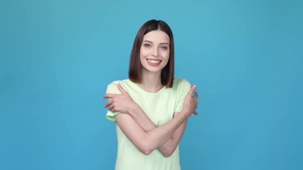 Belle jolie dame câlins mains vous-même isolé fond de couleur bleue — Video