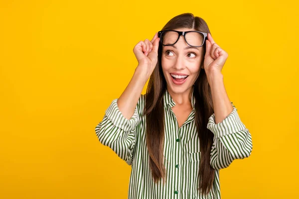 Foto av unga glada glada kvinna händer röra glasögon ser tomt utrymme nyfiken isolerad över gul färg bakgrund — Stockfoto