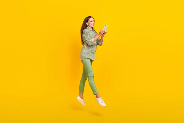 Полноразмерная фотография профиля барышни, использующей сотовый телефон для связи комментария 4g прыжок изолированный на желтом цветовом фоне — стоковое фото