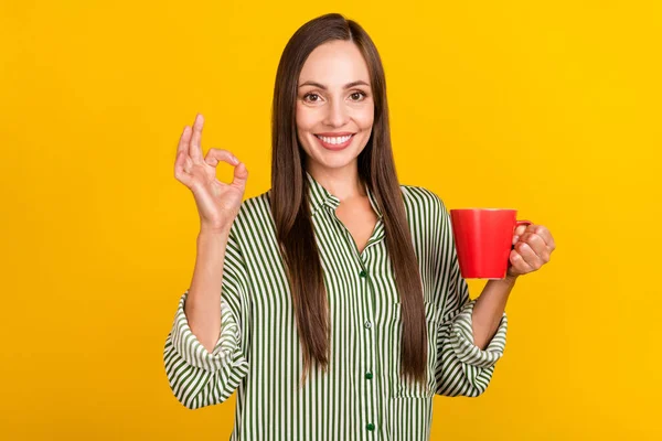 Neşeli genç bayanın fotoğrafı americano latte 'nin tadını çıkarın parmaklarınızı gösterin tamam mükemmel bir reklam sarı arka planda izole edilmiş — Stok fotoğraf