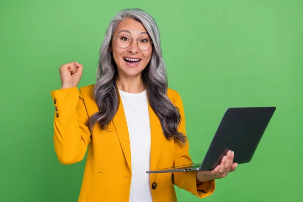 Photo of mature woman celebrate victory goal lucky fists hand marketer isolated over green color background — Stock Photo, Image