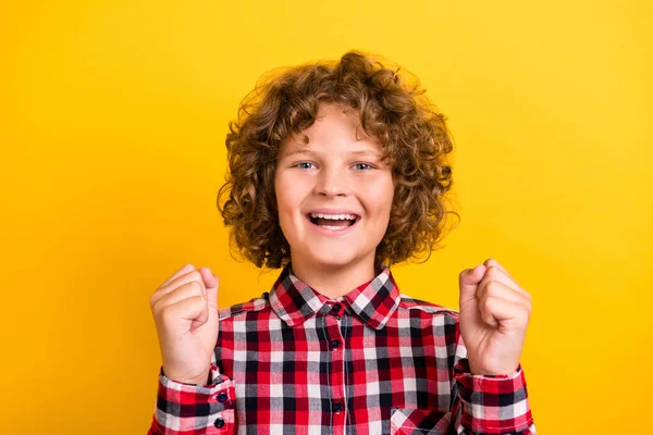 Foto de hooray laranja ondulado penteado pequeno menino mãos punhos desgaste vermelho camisa quadriculada isolado no fundo de cor amarela — Fotografia de Stock