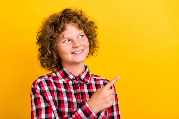 Foto de hermoso peinado naranja adolescente chico indican espacio vacío usar camisa a cuadros rojo aislado en el fondo de color amarillo — Foto de Stock