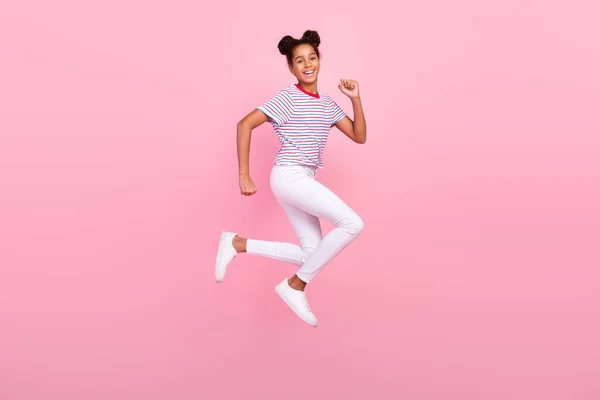 Foto de cuerpo completo de la niñez afroamericana morena pelo elegante chica de moda usar ropa casual salto correr aislado sobre fondo de color rosa —  Fotos de Stock