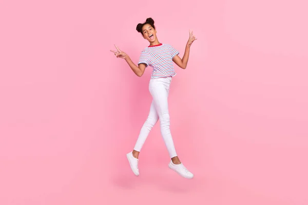 Foto em tamanho completo de cabelo castanho bun elegante menina afro-americana usar roupas casuais salto passeio fazer v-sinal isolado no fundo cor-de-rosa — Fotografia de Stock