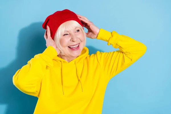 Foto van dromerig oud gelukkig mooi vrouw kijken leeg ruimte dragen rood hoed goed humeur geïsoleerd op blauwe kleur achtergrond — Stockfoto