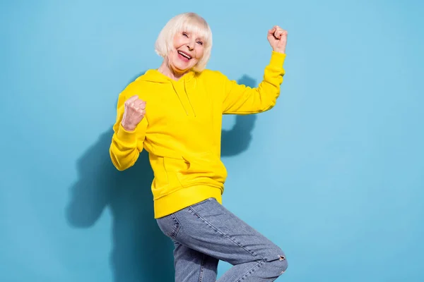 Φωτογραφία από χαρούμενα γλυκιά ηλικιωμένη γυναίκα αυξήσει τις γροθιές φορούν casual ρούχα νικητής απομονώνονται σε μπλε φόντο χρώμα — Φωτογραφία Αρχείου