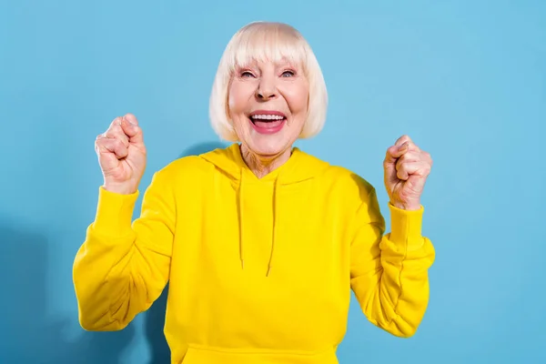Foto veselé pěkné staré pozitivní dáma zvýšit pěsti vítěz dobré nálady izolované na pastelové modré barvy pozadí — Stock fotografie