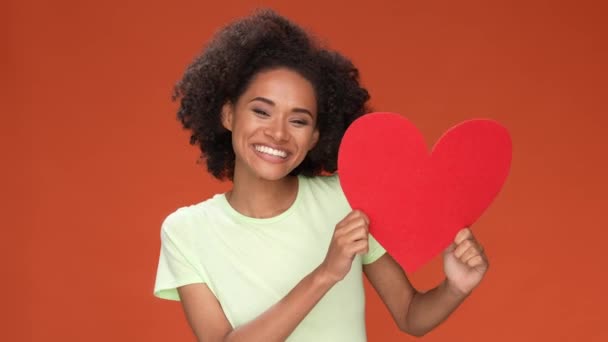 Señora punto corazón abrazo presente aislado naranja oscuro bayas color fondo — Vídeos de Stock