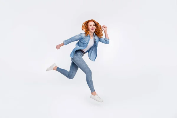 Foto lateral de perfil de cuerpo completo de una atractiva mujer joven y agradable correr espacio vacío saltar aislado sobre fondo de color gris —  Fotos de Stock