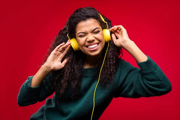 Foto van koele golvende kapsel millennial dame luisteren muziek dragen groene trui geïsoleerd op rode kleur achtergrond — Stockfoto