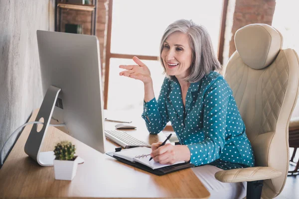 Profil foto av positiva gamla dam prata bärbar dator skriva sitta bära blå skjorta arbete hemma ensam — Stockfoto